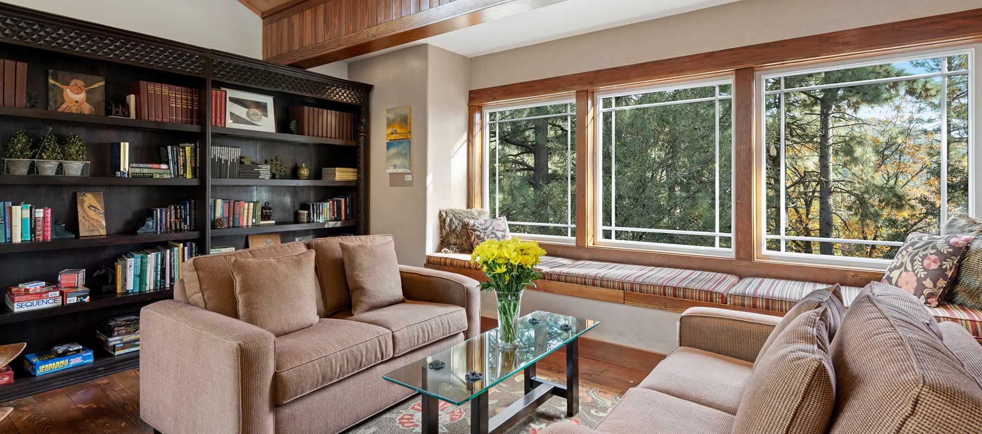 Grand Idyllwild Lodge Library bookcase and sofas with forest view