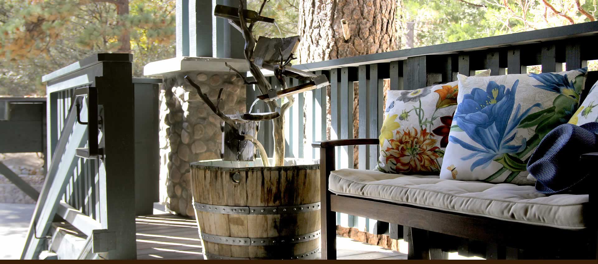 Grand Idyllwild Lodge front porch bench with pillows and fountaimn